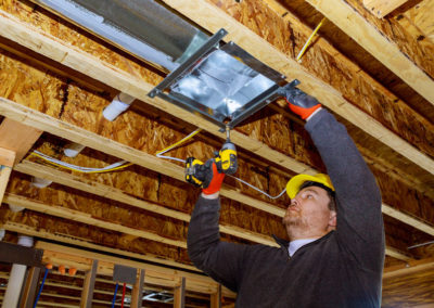 Male technician mounted air conditioner on ceiling ventilation