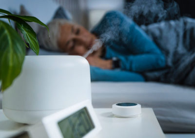 Air Humidifier Increasing the Humidity in a Bedroom. Beautiful Mature Woman Sleeping in Bed